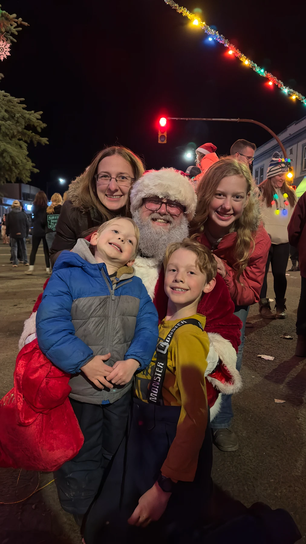 Santa Bryce and his family gathered beneath Christmas lights